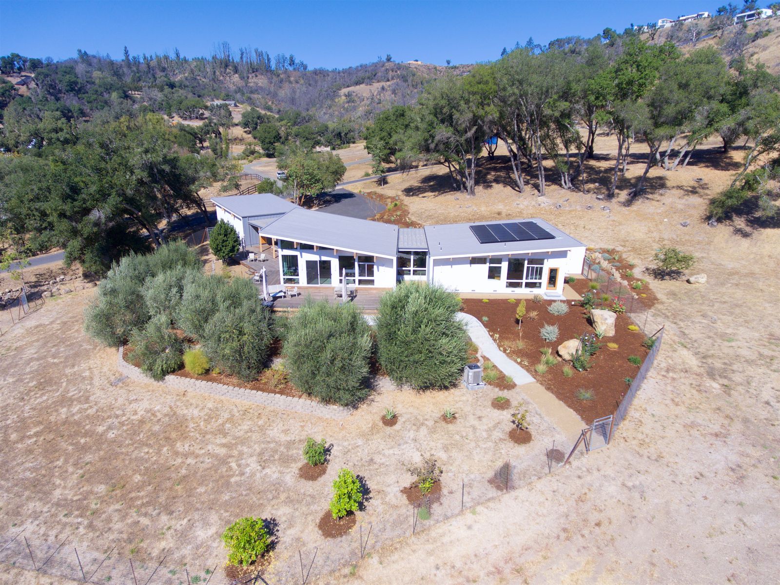 Aerial - completed home with solar, oak-studded site - Howard Construction Inc.